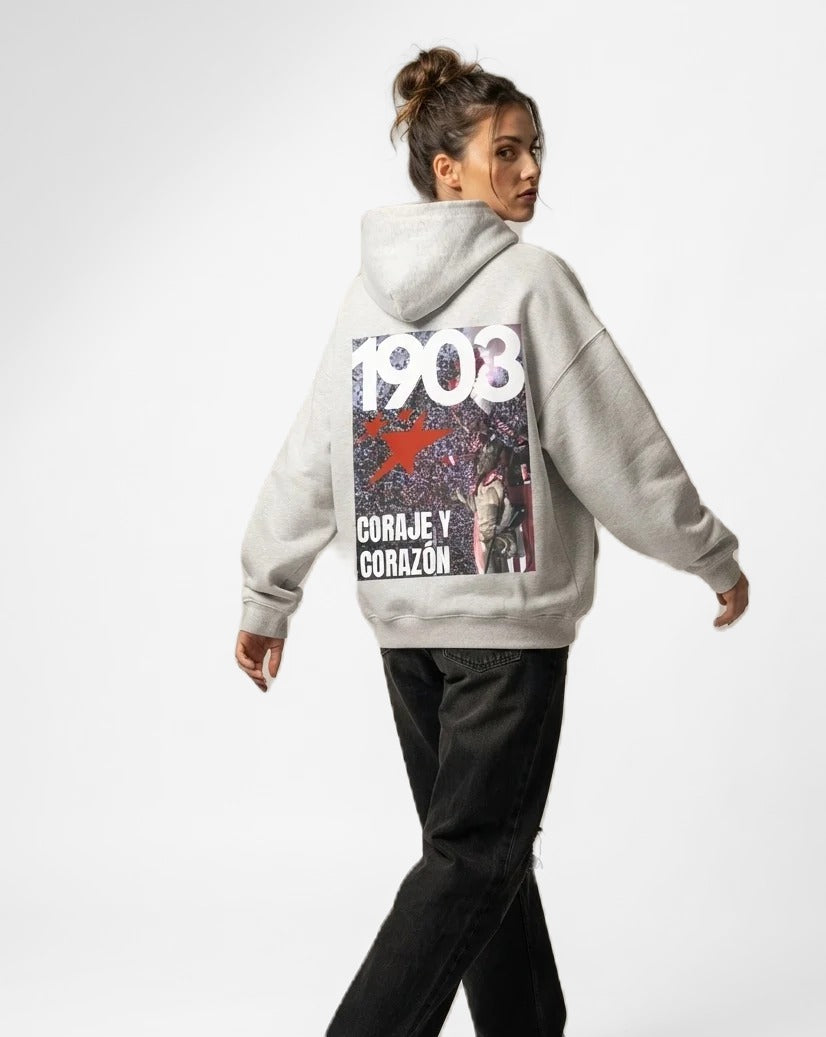 Sudadera con capucha Coraje y Corazón gris puesta, estudio