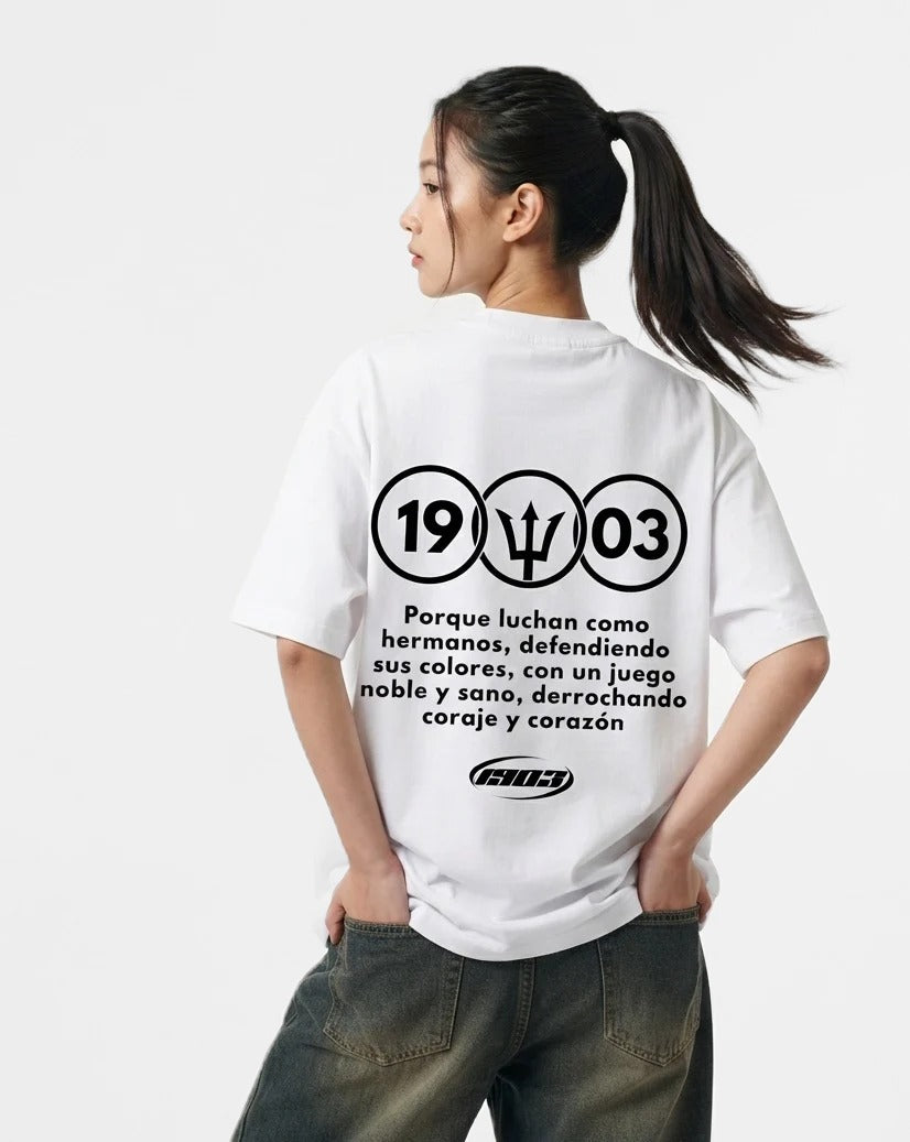 Camiseta Luchan Como Hermanos blanca puesta, estudio